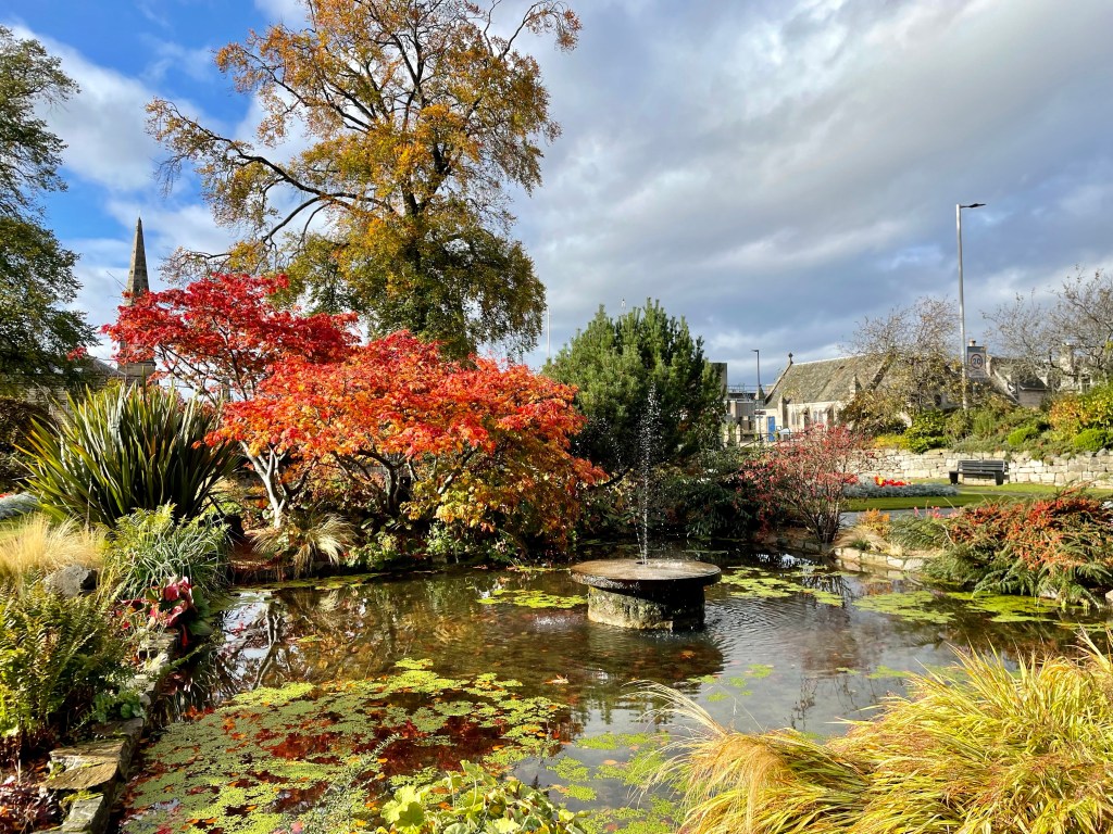Beautiful sunken garden with fountain and autumn coloured bushes  