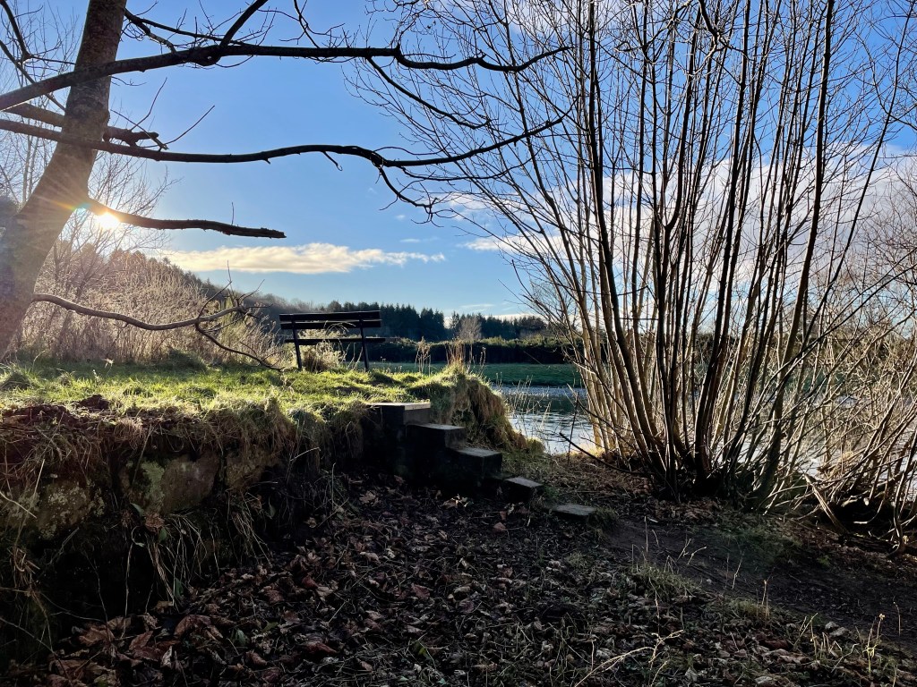 Small set of steps with grass area and view of the river 